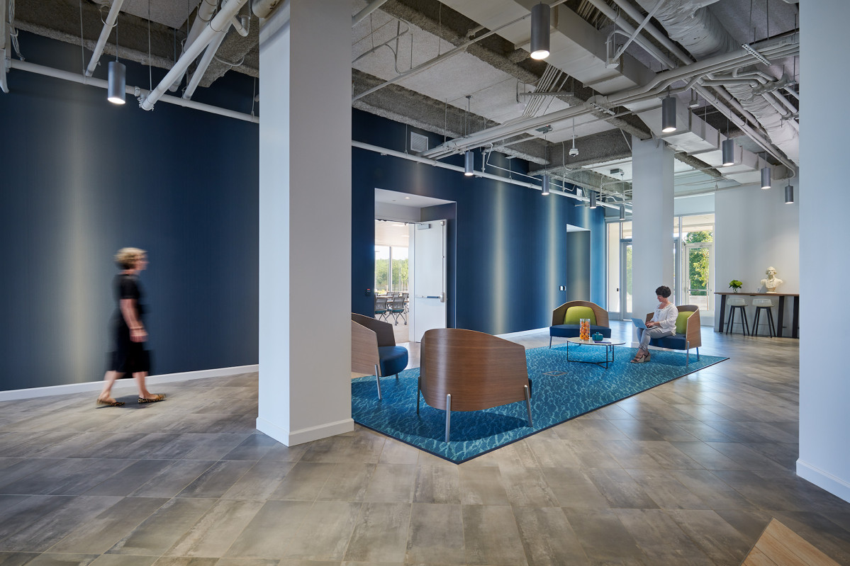 four modern club chairs are arranged in a large industrial space