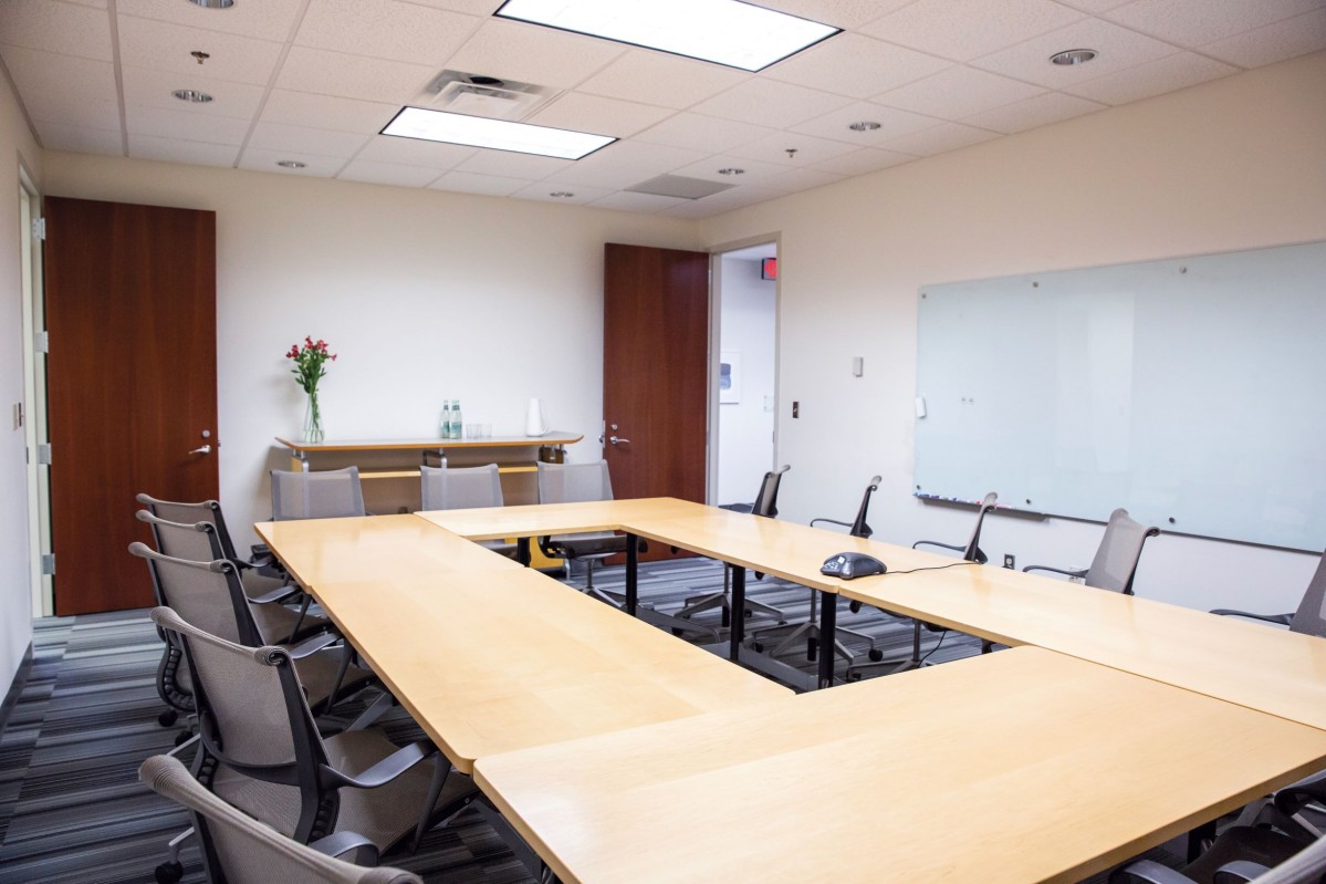 grey office chairs surround mobile oak tables in a meeting room