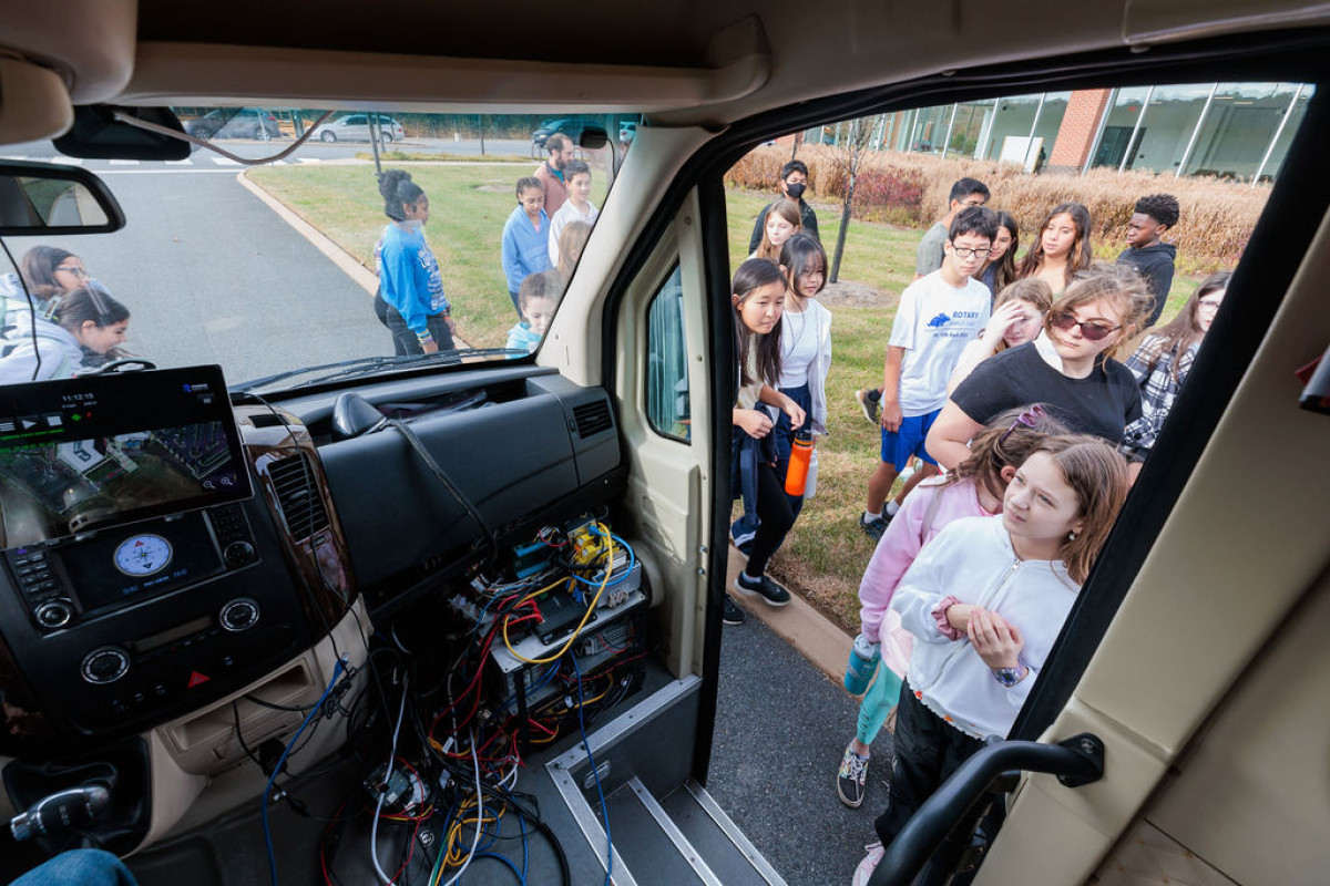 students peer into an autonomous vehicle