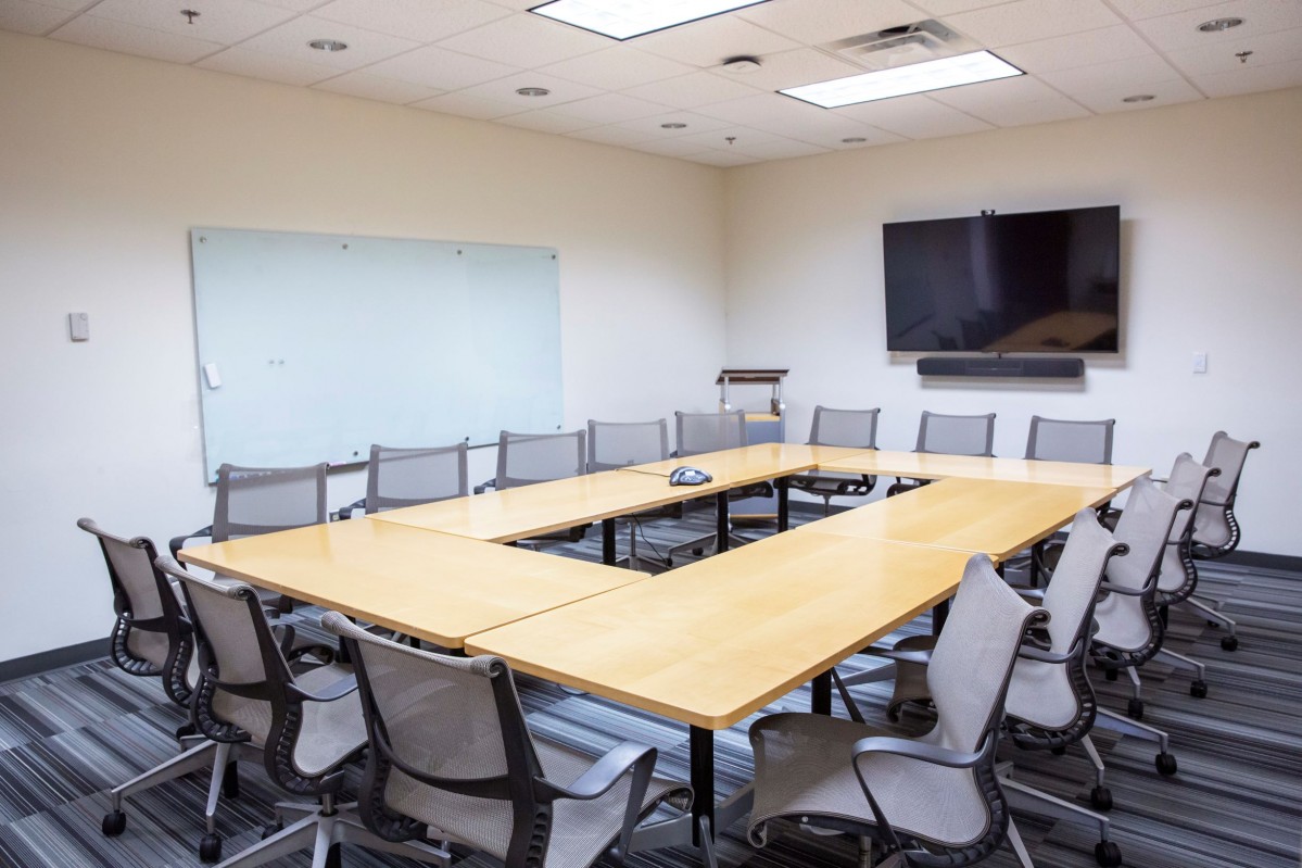 grey office chairs surround mobile oak tables in a meeting room
