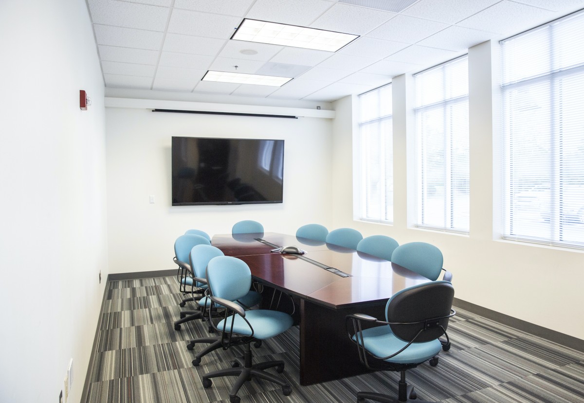 aqua colored chairs surround a polished wood conference table