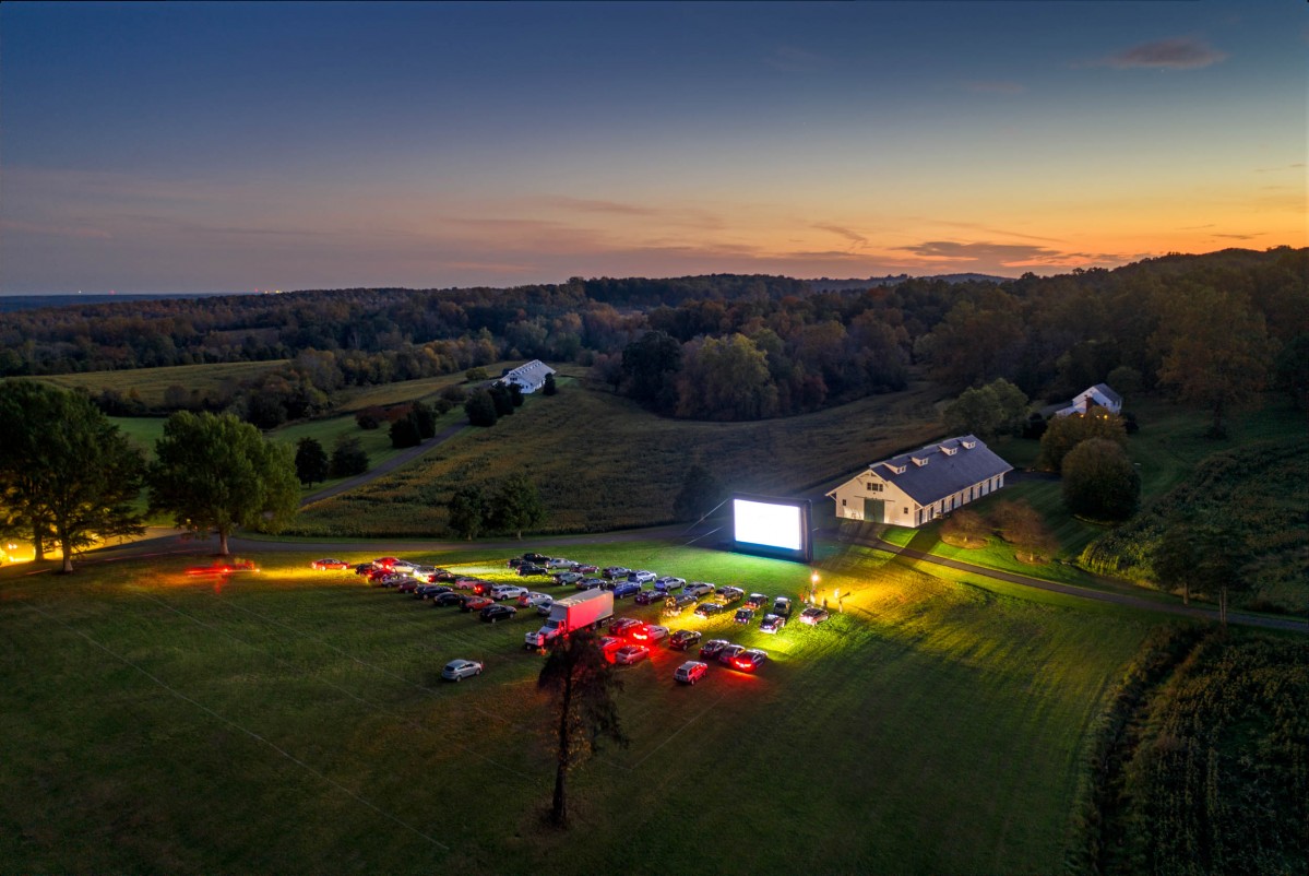 An aerial view of Morven Farm as the sun sets and cars arrive for a drive in movie